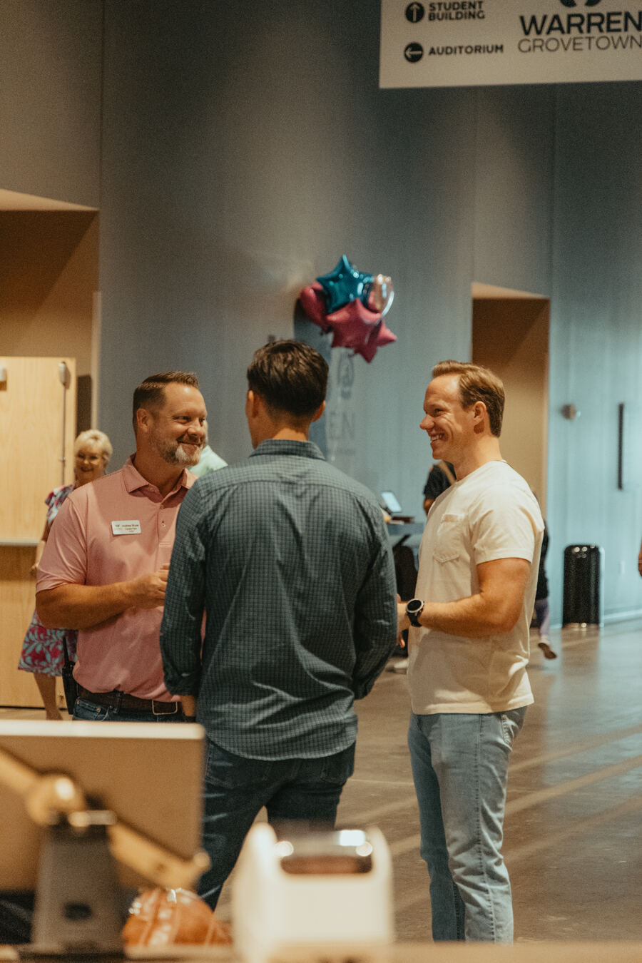 Three men talking in the Grovetown lobby.
