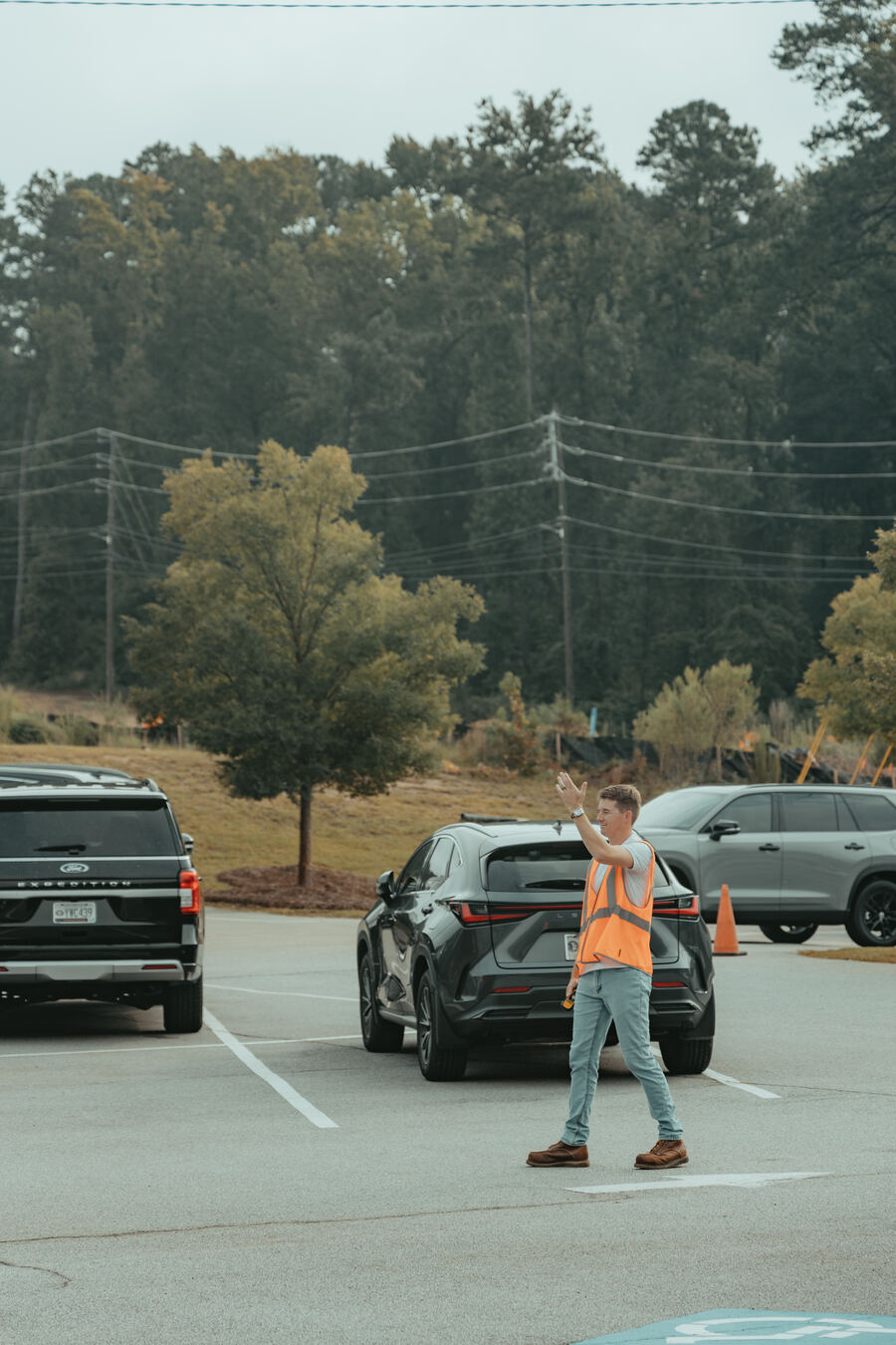 A parking team member waving cars in at Grovetown.