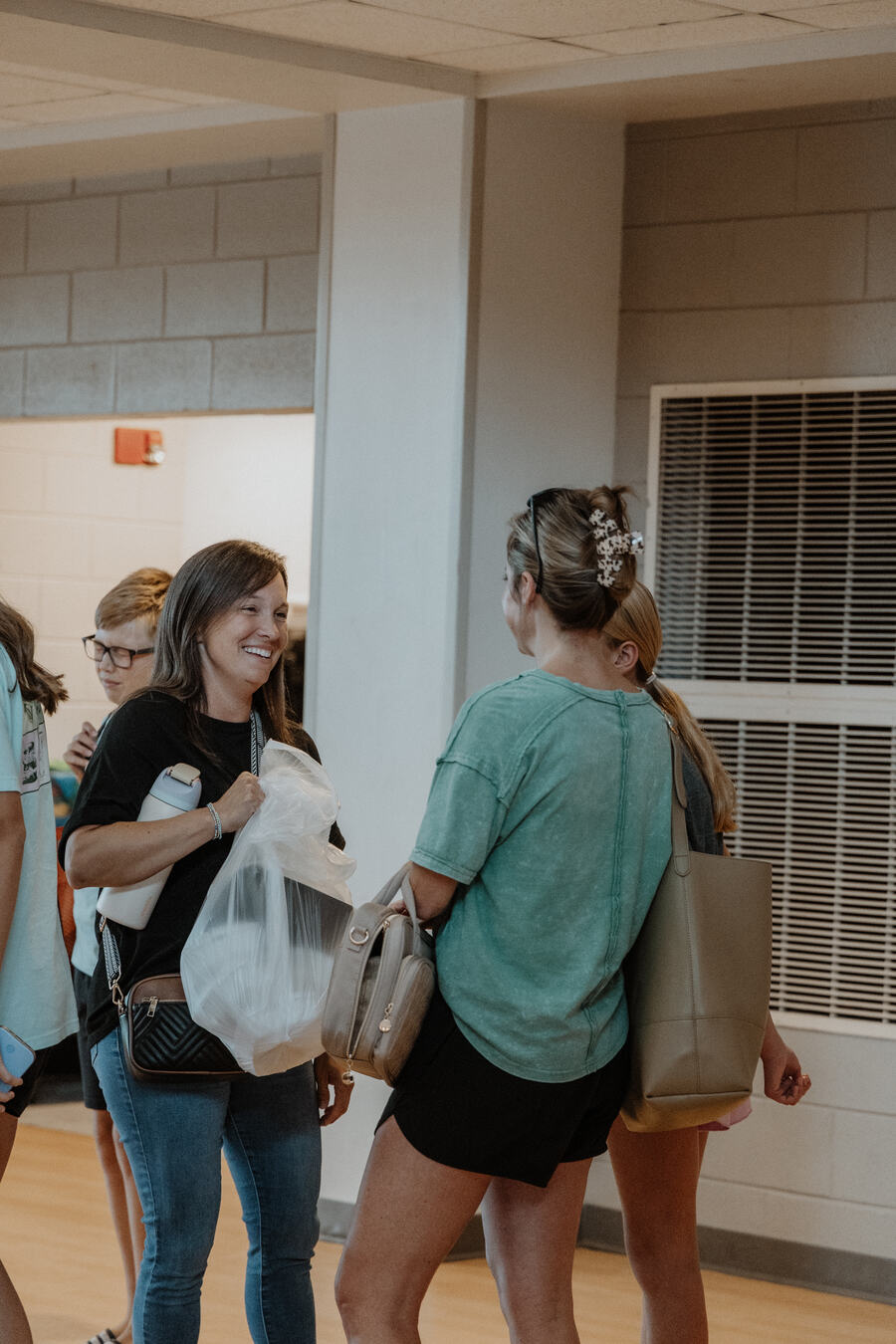 Two women laughing together in a hallway at Midweek at Warren.