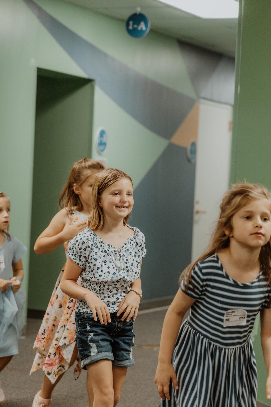 Smiling girls walking down a hallway at Midweek at Warren.