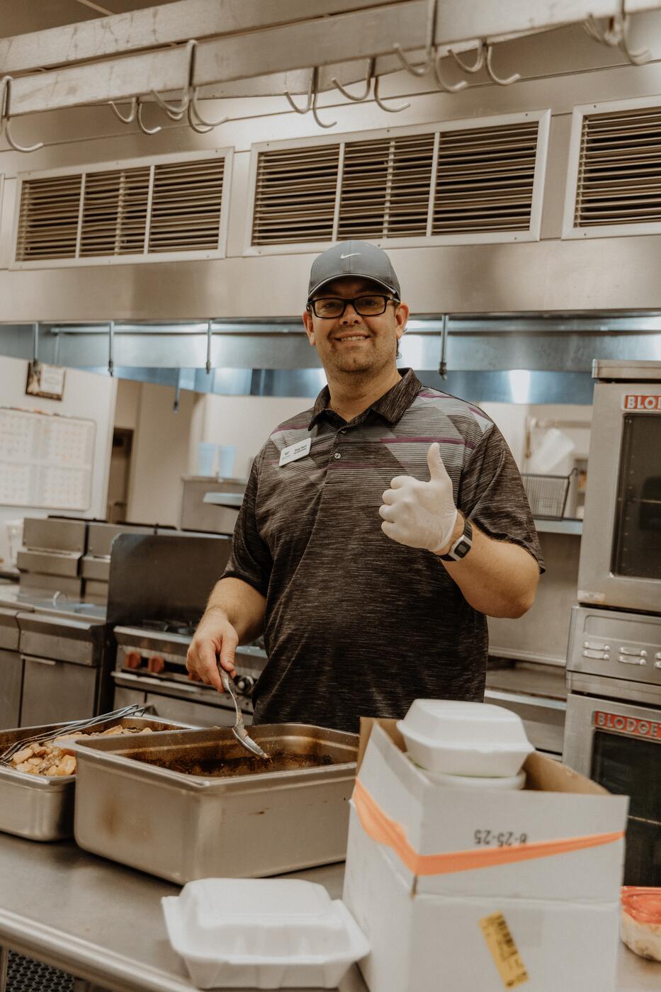 A volunteer serving food in the Warren kitchen.