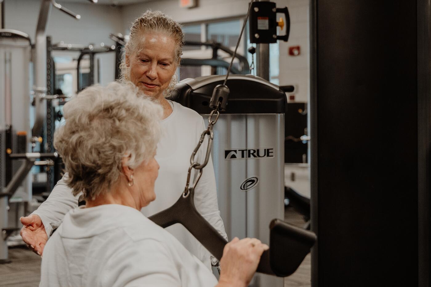 Helping a member set up on a weight machine.