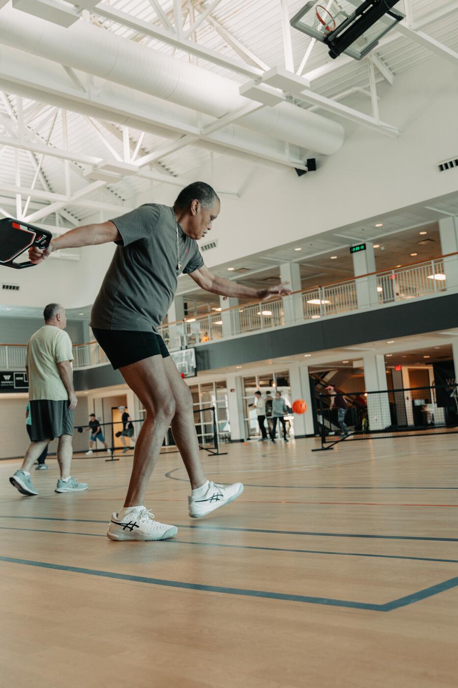 A player mid-swing during a pickleball rally.