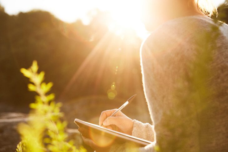 Woman writing outdoors